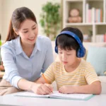 Guru privat membantu anak berkebutuhan khusus belajar menulis di rumah dengan suasana ruang tamu yang nyaman dan tenang.